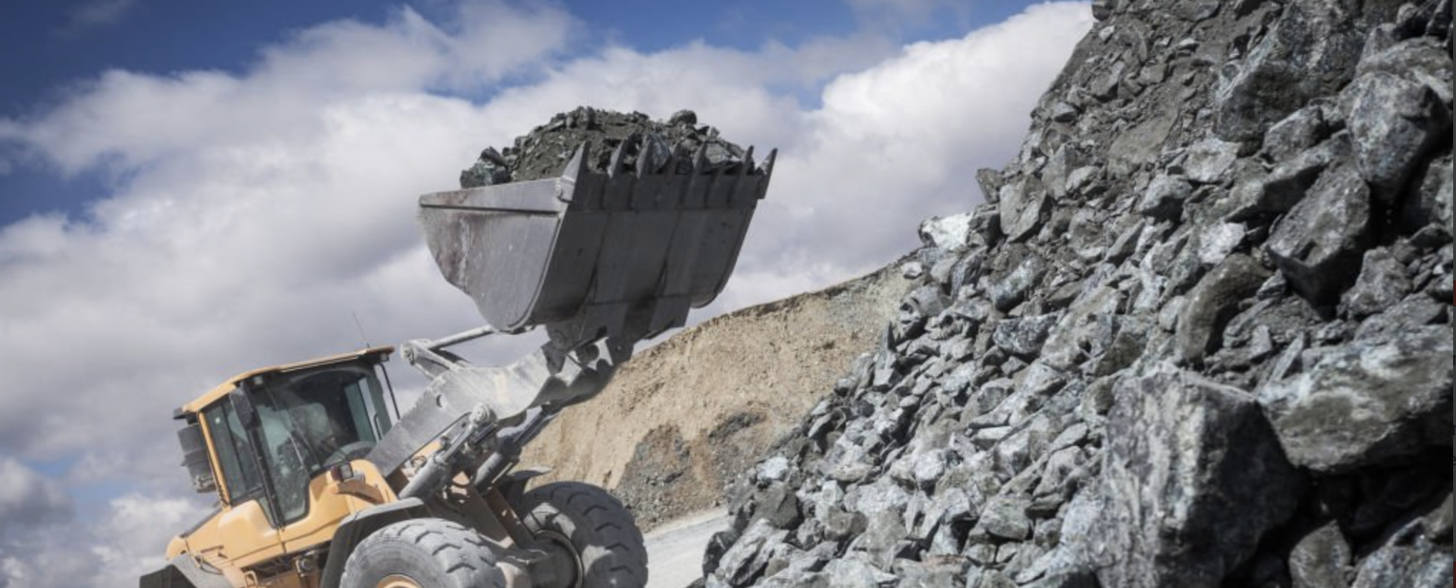 Loader handling raw material at a quarry